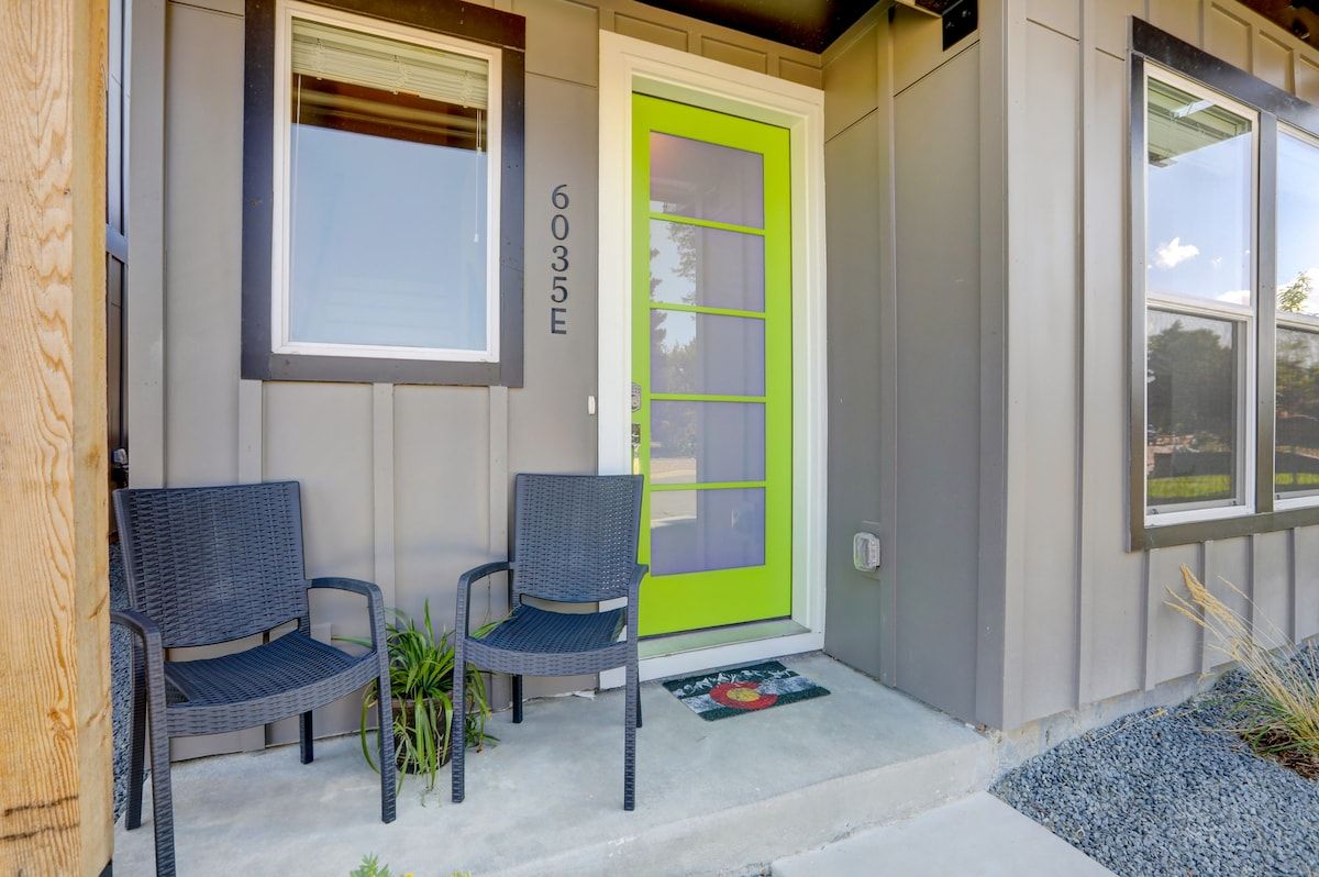Front entry with a green door and patio chairs