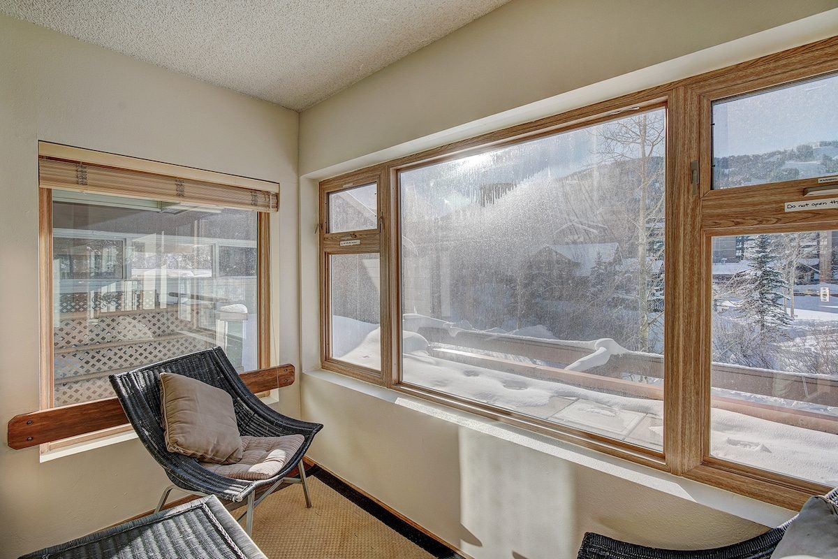 Sunroom with chairs and windows facing the mountain