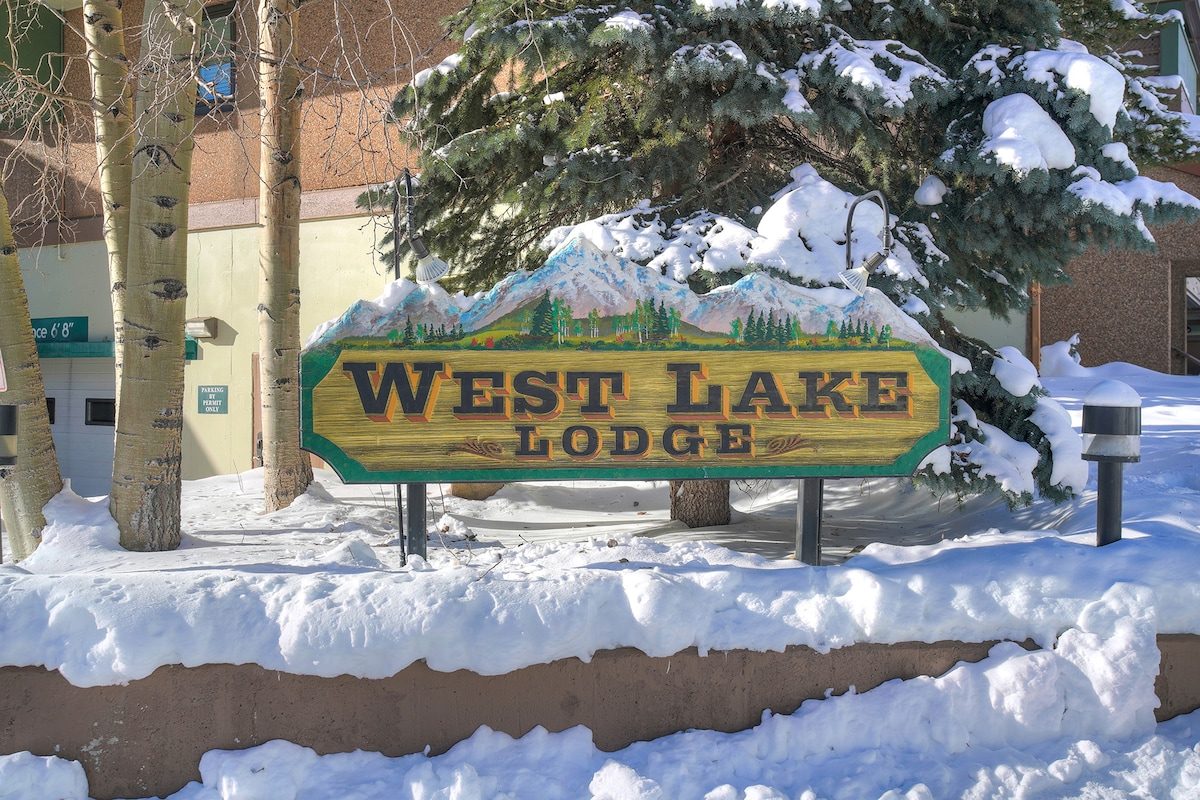 West Lake Lodge sign in the snow among aspens