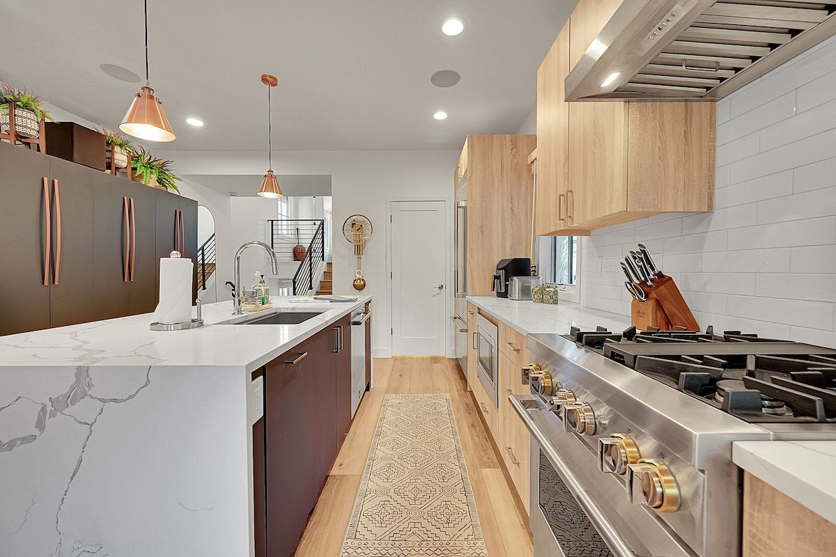 Galley kitchen with a gas range and copper pendant lights