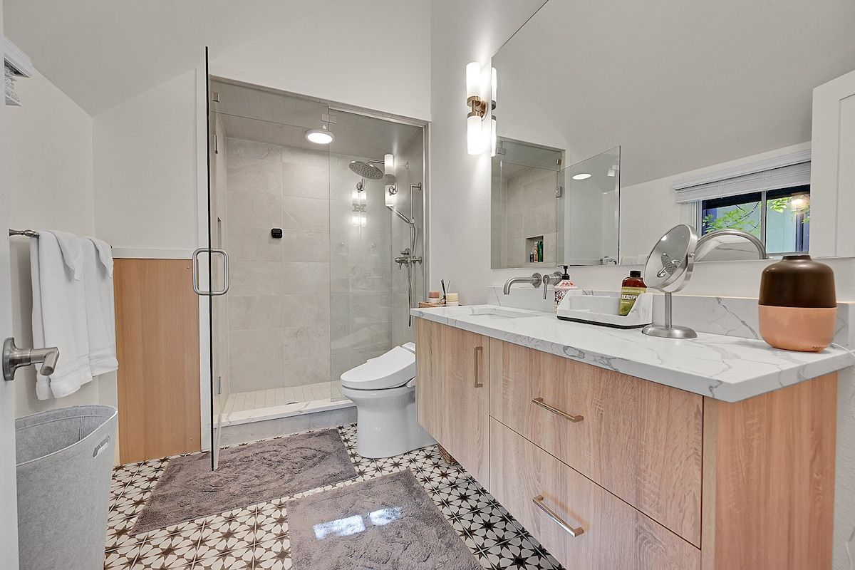 Bathroom with a glass shower and a patterned tile floor