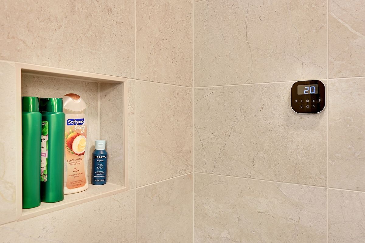 Steam shower with a recessed niche and a digital control