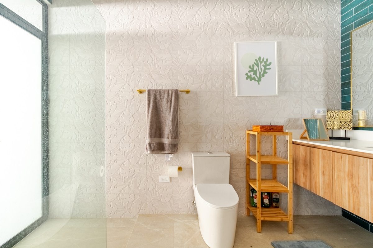 Bathroom with teal tile and a glass shower
