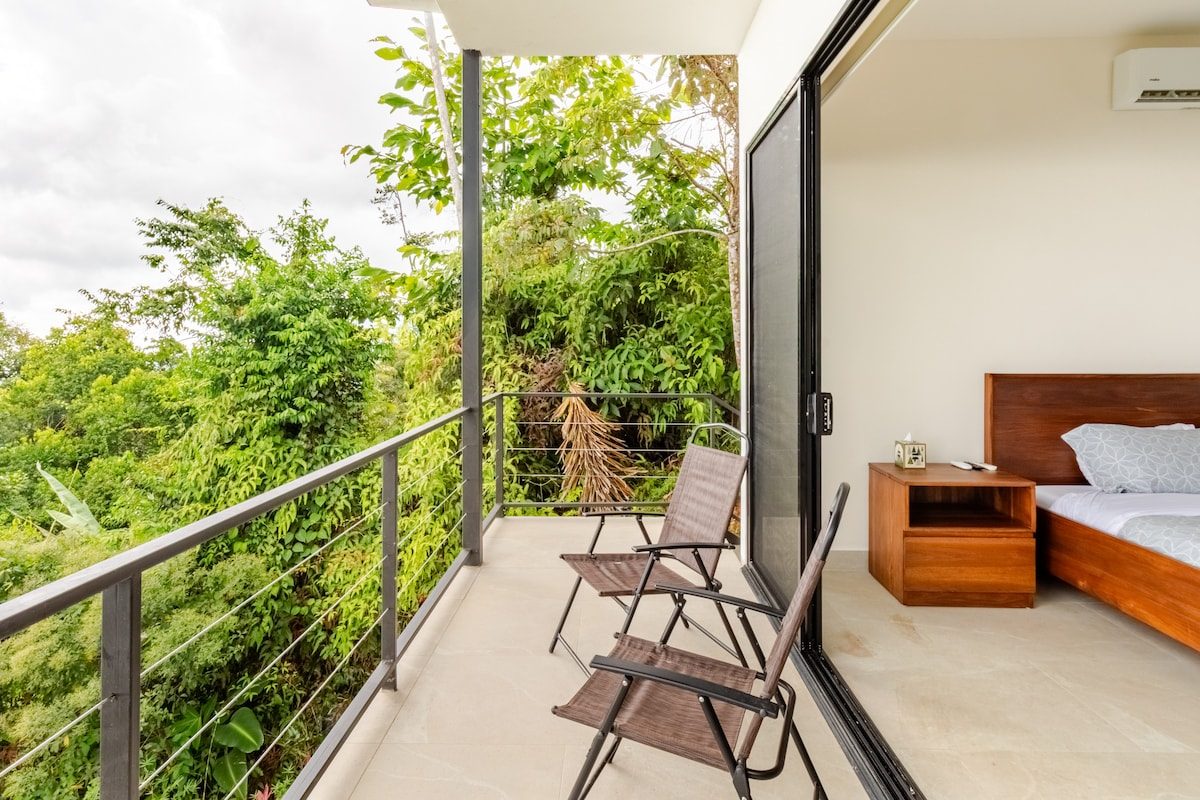 Bedroom opening onto a balcony over the jungle