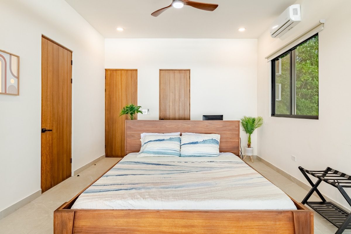 Bedroom with a king bed and a window onto the jungle