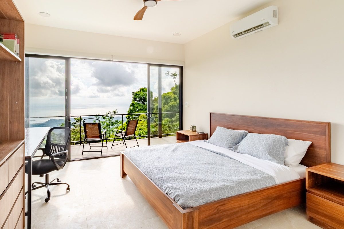 Bedroom with sliding doors onto a balcony with an ocean view