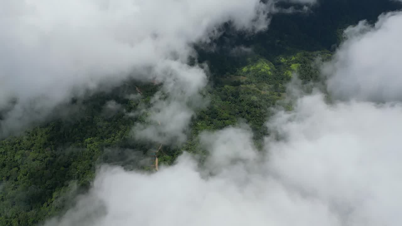 Aerial view descending through cloud over the jungle hillside above the villa