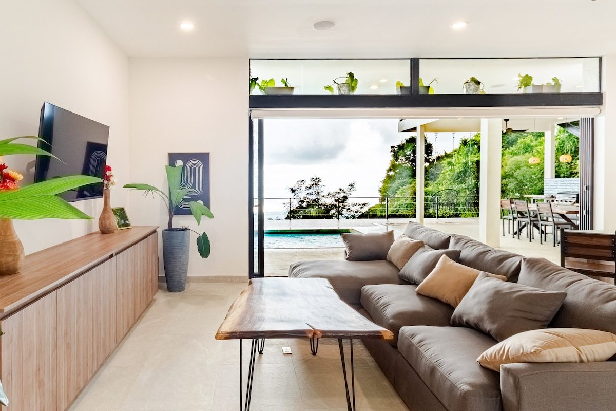 Living room with sofa and TV, opening onto the pool terrace